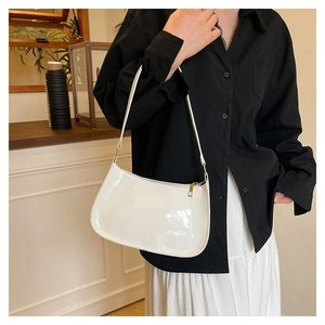 Close-up of a white glossy patent leather baguette bag with sleek minimalist design