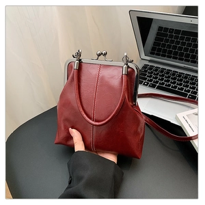 Vue détaillée d'un sac vintage bordeaux avec fermoir métallique et texture similicuir