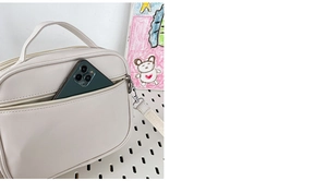 Detail of white transparent ita bag showing front pocket storage and detachable strap