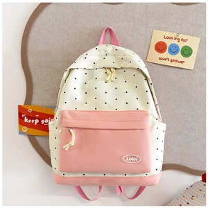 Close-up of polka dot canvas backpack with pink zipper pocket and Lolo logo details