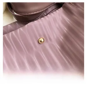 Macro shot of mauve pleated leather texture and a polished metallic spherical stud detail