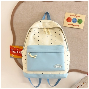 Close-up of a polka dot school backpack with Lolo logo and light blue canvas details