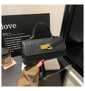 Detail of woven texture handbag featuring a golden rotary lock and elegant French style