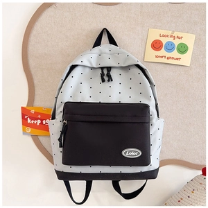 Detail shot of white polka dot backpack with black panel and Lolo logo patch