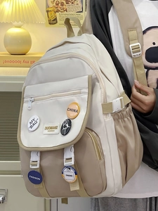 Detail of multi-pocket canvas school backpack with decorative badges and side pocket