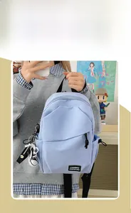 Detail showing light blue nylon crossbody bag with geometric pocket and mini shoe pendant