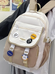Detail of contrast color school backpack with trendy badges and secure buckle closure