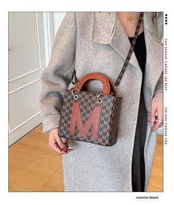 Detail view of vintage brown monogram bag with a large M patch and sleek gold hardware