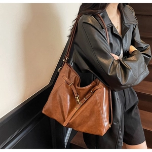 Detail of the vintage dark brown tote bag showing the textured finish and golden buckle