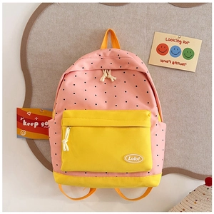 Close-up of pink polka dot kids backpack with yellow pocket and orange straps detail