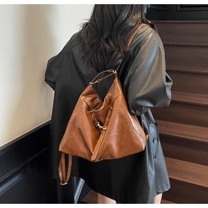 Rear view of model wearing a vintage brown leather tote bag on wooden stairs