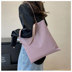 Detail view of purple corduroy tote bag showing vertical ribbed texture and shoulder strap