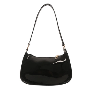 Minimalist black glossy faux leather underarm bag with gold metal hardware on white background