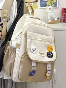 Detail view of stylish canvas backpack featuring decorative badges and functional zippers