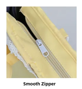 Detail eines glatten Reißverschlusses und weißer Spitze an einer gelben Stofftasche