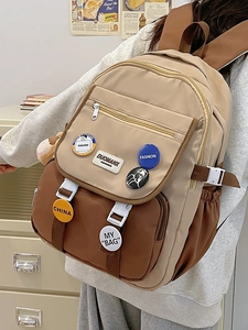Detail of a casual patchwork school backpack with fashion badges and brown straps