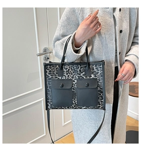 Close-up of leopard print tote bag featuring dual front pockets and shoulder straps