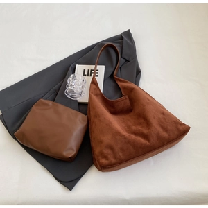 Detail of caramel suede hobo bag set including matching flat leather zipper pouch accessory