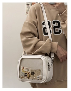 Detail of white ita bag with large clear PVC window and adjustable shoulder strap