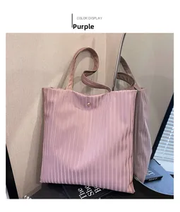 Detail view of purple pleated tote bag featuring metallic finish and golden metal buckle