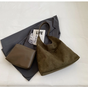 Close-up of olive green suede tote bag with matching leather clutch and smooth texture