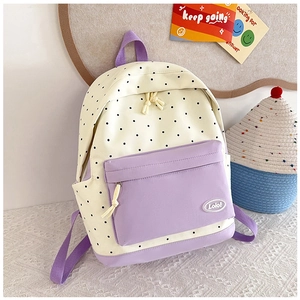 Detailed view of polka dot school backpack with purple straps and pockets in a campus setting