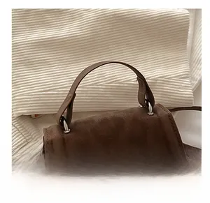 Dettaglio del manico della borsa marrone scuro con fibbia in metallo e stile retrò