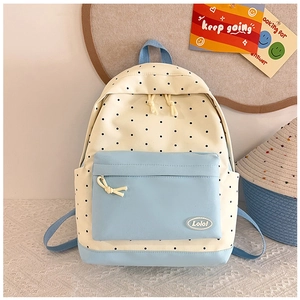Detailed view of the star polka dot backpack with a blue zip pocket and Lolo logo badge