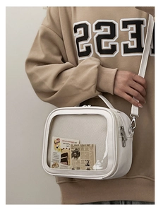 Detailed side view of white PU leather Ita bag with clear window and metal strap