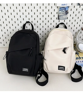 Close-up of minimalist nylon crossbody bags with brand label and front zipper detail