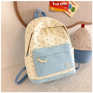 Detailed view of polka dot backpack with light blue front pocket and logo label