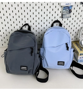 Close-up of lightweight nylon mini backpacks in grey and blue with side drawstrings