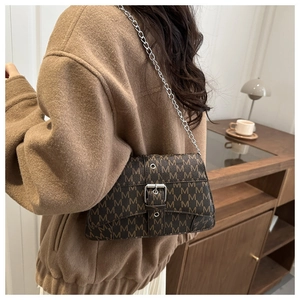 Close-up of vintage brown leather crossbody bag with M-letter pattern and silver chain strap