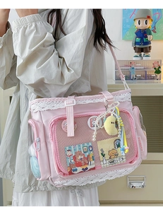 Detailansicht der rosa Ita-Tasche mit weißem Spitzenbesatz und transparentem Fenster