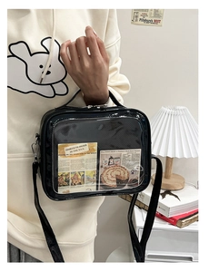 Detail of a black square bag with a clear PVC window and vintage illustration insert