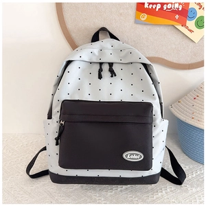 Detail view of stylish polka dot backpack featuring a durable front zipper pocket and logo