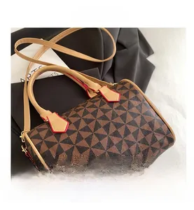 Détail du sac Boston avec motifs géométriques, poignées en cuir et bordures rouges vives