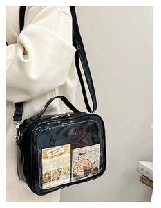 Glossy black ita bag with transparent window and adjustable strap shown on model