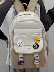 Detail view of stylish color-block school backpack with decorative fashion badges