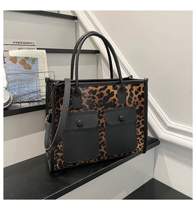 Detail of leopard print tote bag with matte black pockets and detachable shoulder strap