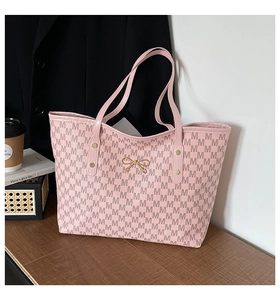 Vue détaillée du sac cabas rose avec imprimé à motif M et nœud doré décoratif