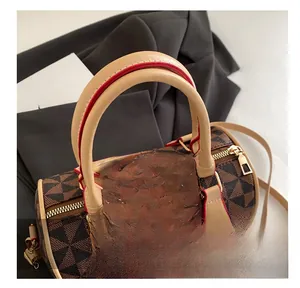 Détail du sac cylindrique marron avec finitions dorées et bordures en cuir de haute qualité
