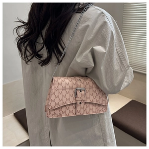 Close-up of pink crossbody bag featuring M-letter pattern and silver chain strap