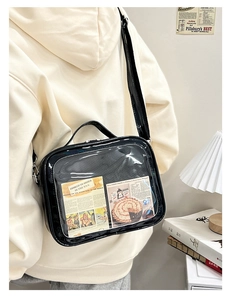 Detail view of black glossy ita bag with transparent window and retro paper insert