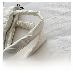 Vue détaillée des poignées rembourrées et du nylon matelassé de ce grand sac blanc