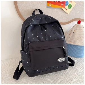 Detailed shot of black polka dot canvas backpack featuring zipper pocket and Lolo label