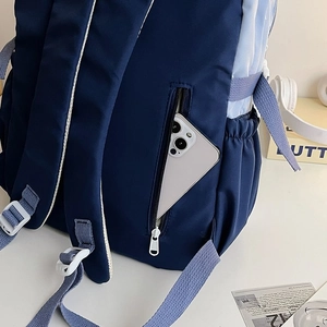 Detail of blue school backpack featuring hidden anti-theft zipper pocket and phone storage