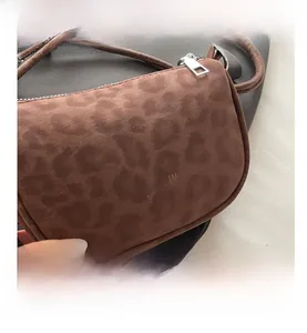 Gros plan d'un sac bandoulière léopard avec texture mate et détail de fermeture éclair
