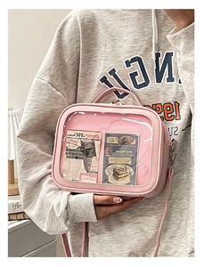 Close-up of pink ita bag with transparent window, showing decorative inner cards and PU texture