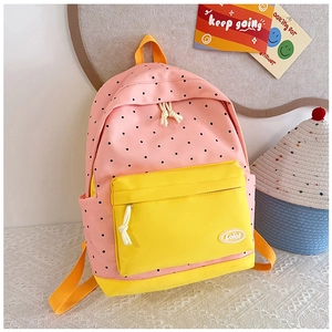 Detailed close-up of a pink polka dot school backpack with yellow pockets and rope zipper pull